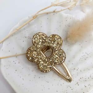 Barrette Fleur Champagne en résine dorée posée sur fond clair, accessoire cheveux fait main en Bretagne