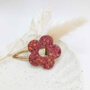 Barrette Fleur Rose en résine rose transparente posée sur fond clair, accessoire cheveux fait main en Bretagne