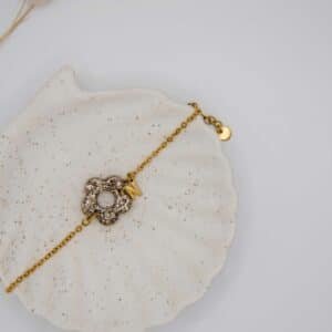 Le bracelet Oamaru en acier inoxydable doré avec pendentif fleur en résine fabriqué à la main et option initiale en breloque personnalisable