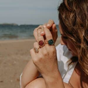 Ensemble de bagues sonora rubis riviera aux pierres rouges et dorures fines présentées sur une surface claire dans une lumière douce