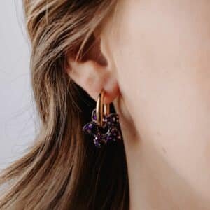 Créoles Maui Sombra avec fleurs de tiaré en résine pailletée violette et noire, bijou artisanal fait main en Bretagne, chic et tropical