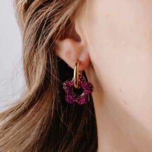 Créoles Oia Aurélia dorées avec fleurs en résine jaune et violette sur fond clair