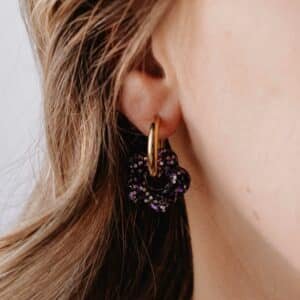 Créoles Oia Sombra dorées avec fleur en résine noire sur fond clair