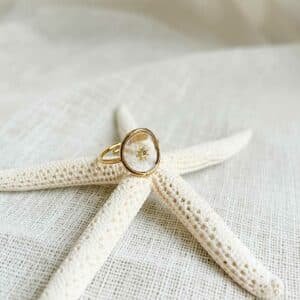 Bague Mexico plaqué or 18k fine et élégante posée sur une surface claire avec reflets doux et détails minimalistes lumineux