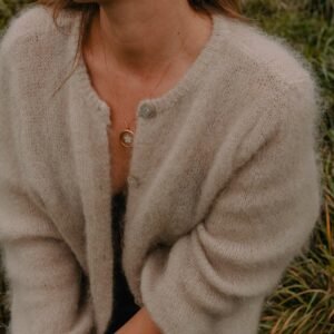 Collier Arles avec pendentif rond doré et motif fleur délicat sur fond clair – création Atelier R.