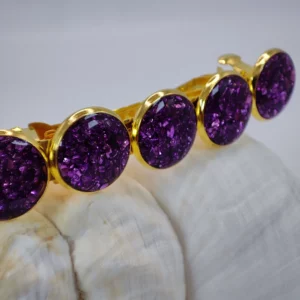 Pince à cheveux violette Paris Lavande avec cinq pastilles en résine violette scintillante montées sur une base dorée.