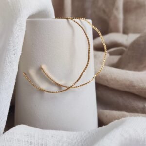 Jonc Whitehaven doré en acier inoxydable avec forme ondulée souple et design minimaliste